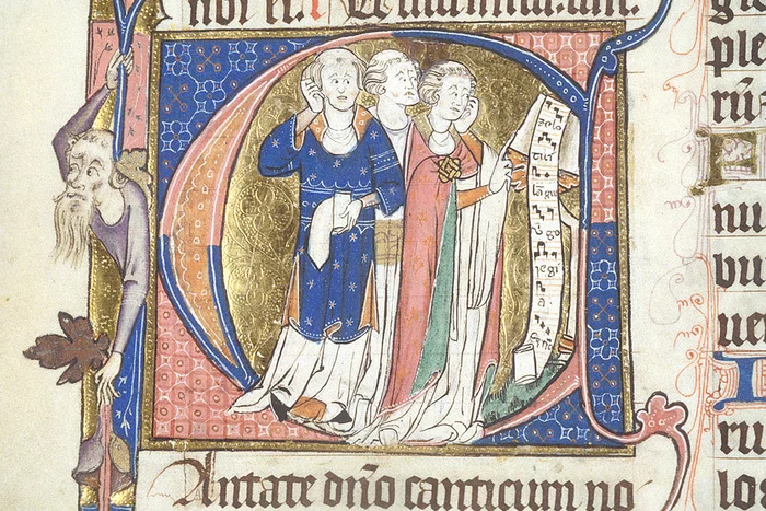 Manuscript initial of the letter C. Within the letter can be seen three clerics with tonsures, singing the motet Zelo tui langueo from a scroll of music at a lectern. The chief colours of the illumination are red and blue, with gold and green also featuring in the robes and the background.