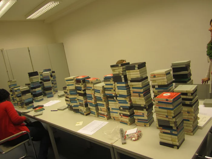 Image of an office with several people working on stacks of the BOLSA audiotapes.
