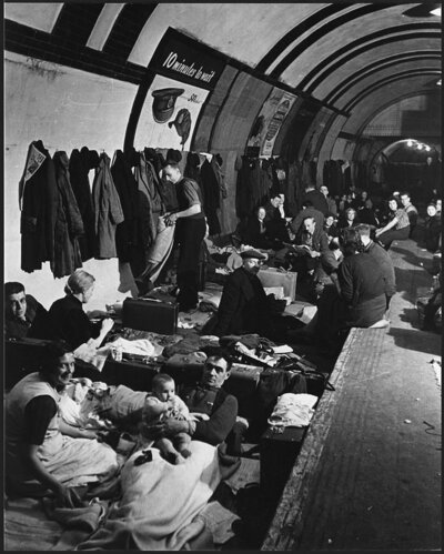 Image of people bedding down for the night in a West End air raid shelter (tube station).