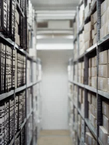 Archive shelves with labelled archive boxes, vanishing perspective.