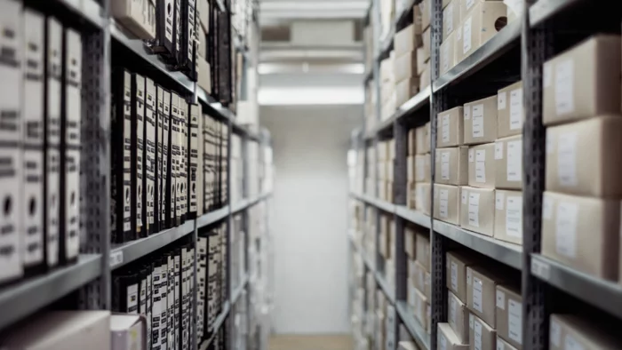 Archive shelves with labelled archive boxes, vanishing perspective.