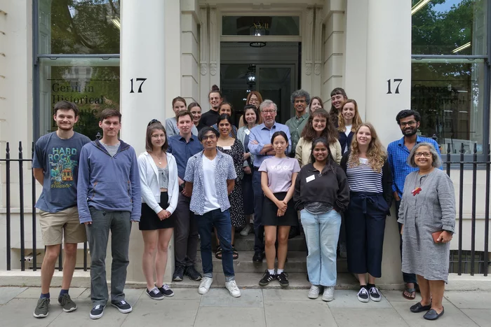 Group photograph of students at the GHIL Summer School 2022, shown on the stairs at the front entrance of the GHIL.