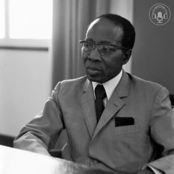 Black and white photograph of Léopold Sédar Senghor, seated. In the top right corner is the GHIL podcast symbol of a microphone and headphones in a circle.