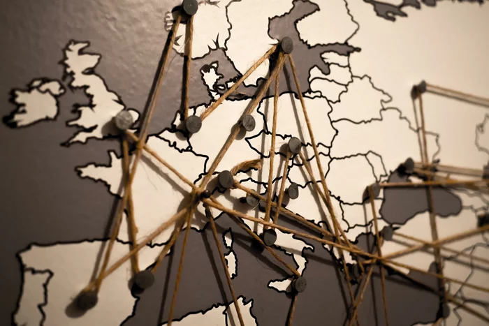 A map of Europe and parts of Asia, with pins connected by string stuck into various locations of the map.