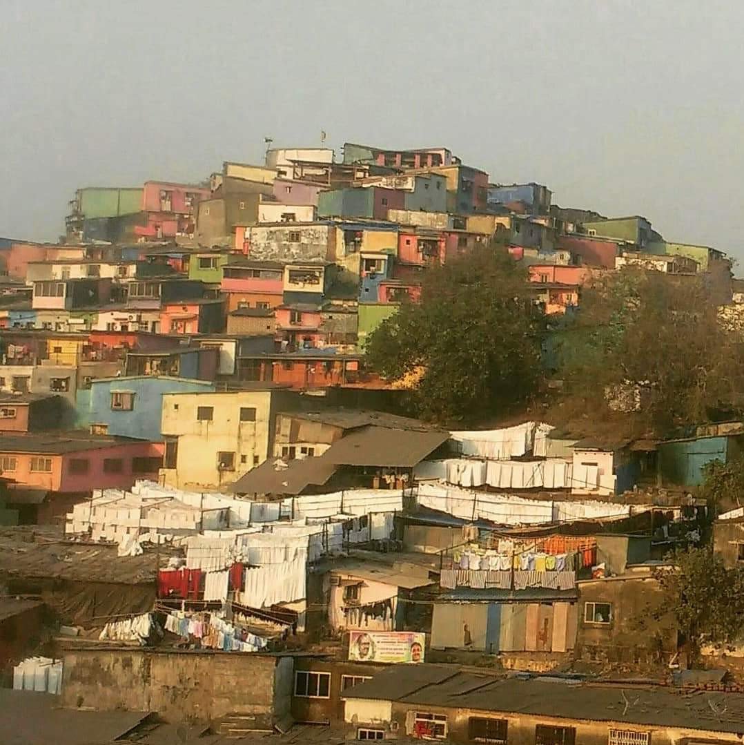 Colourfully painted houses constructed right up to the top of a hill in Mumbai