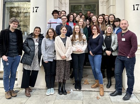 Group of postgraduate students gathered around the entrance to the GHIL