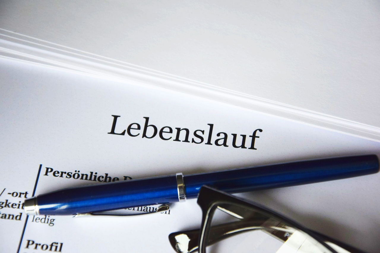 Vacancies A pen and a pair of glasses on top of a CV entitled Lebenslauf